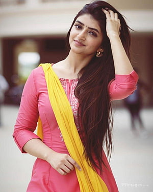 Sreeleela in a pink kurta with a yellow dupatta, posing with long dark hair HD phone wallpaper