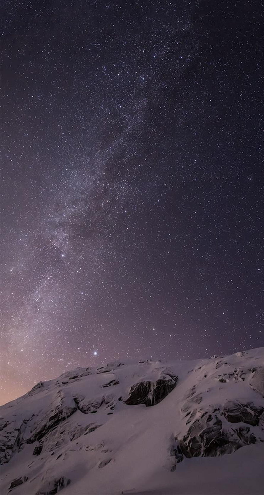 Milky Way Galaxy Arching Over Snow-Covered Mountain Peak at Night HD phone wallpaper