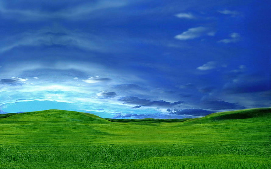 Vibrant Green Rolling Hills Under a Dramatic Blue Sky with Scattered Clouds HD wallpaper
