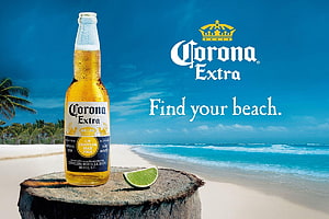 Corona Extra beer bottle with lime wedge on a tropical beach with turquoise ocean and palm trees HD wallpaper
