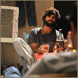 Vijay Deverakonda as Arjun Reddy in a moody indoor scene with a drink HD phone wallpaper