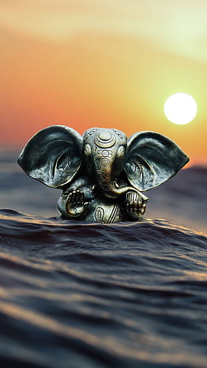 Ganesha Bronze Statue Emerging From Ocean Waves At Sunset HD phone wallpaper