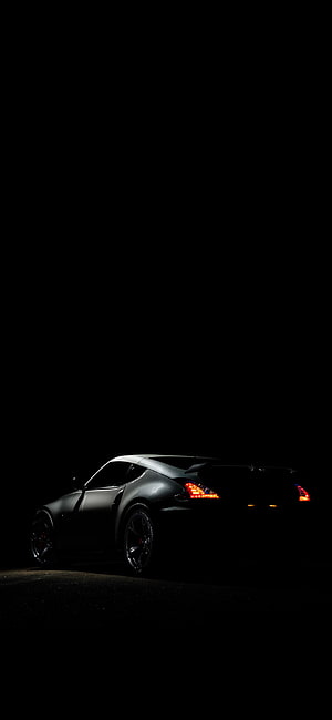 Sleek Sports Car Silhouette with Glowing Taillights Against a Dark Night Sky HD phone wallpaper