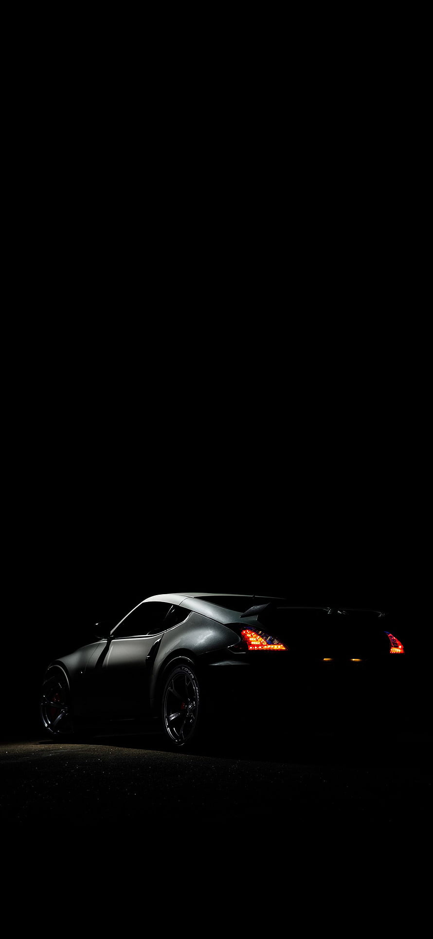 Sleek Sports Car Silhouette with Glowing Taillights Against a Dark Night Sky HD phone wallpaper