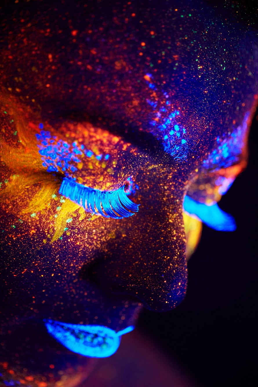 Glowing UV Face Paint Portrait with Neon Blue Lashes and Glitter Under Black Light HD phone wallpaper
