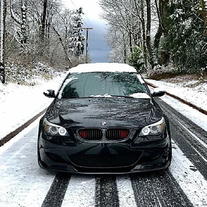 Black BMW M5 E60 Sedan Parked on Snowy Forest Road in Winter HD phone wallpaper