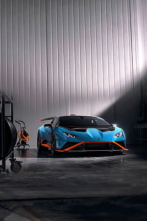 Lamborghini Huracan STO in Blue and Orange Parked in a Modern Industrial Garage HD phone wallpaper