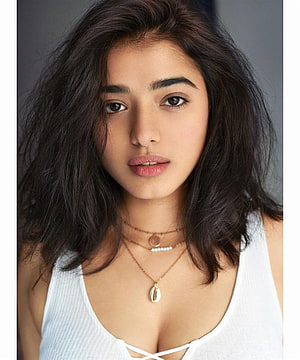 Ketika Sharma Portrait in White Top with Layered Necklaces and Dark Wavy Hair HD phone wallpaper