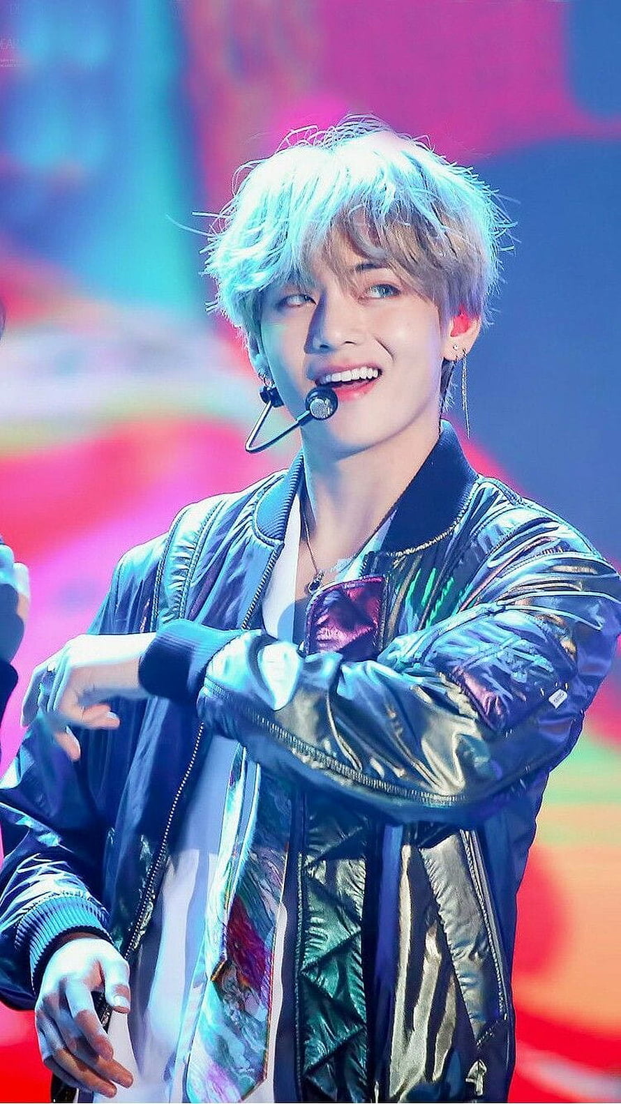 BTS V smiling on stage in a shiny bomber jacket with platinum hair HD phone wallpaper