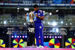 Rohit Sharma holding the IPL trophy on the stadium podium in a Mumbai Indians jersey HD wallpaper