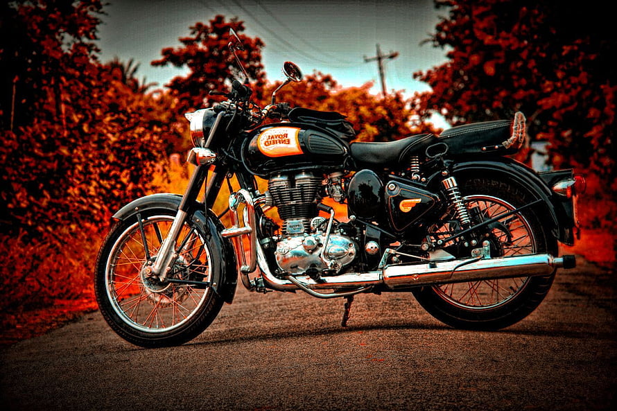 Classic Royal Enfield Bullet Motorcycle Parked on a Gravel Road with Autumn Foliage HD wallpaper