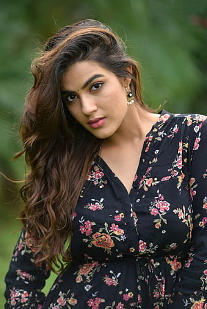 Kavya Thapar in Black Floral Dress with Long Wavy Hair and Gold Earrings HD phone wallpaper