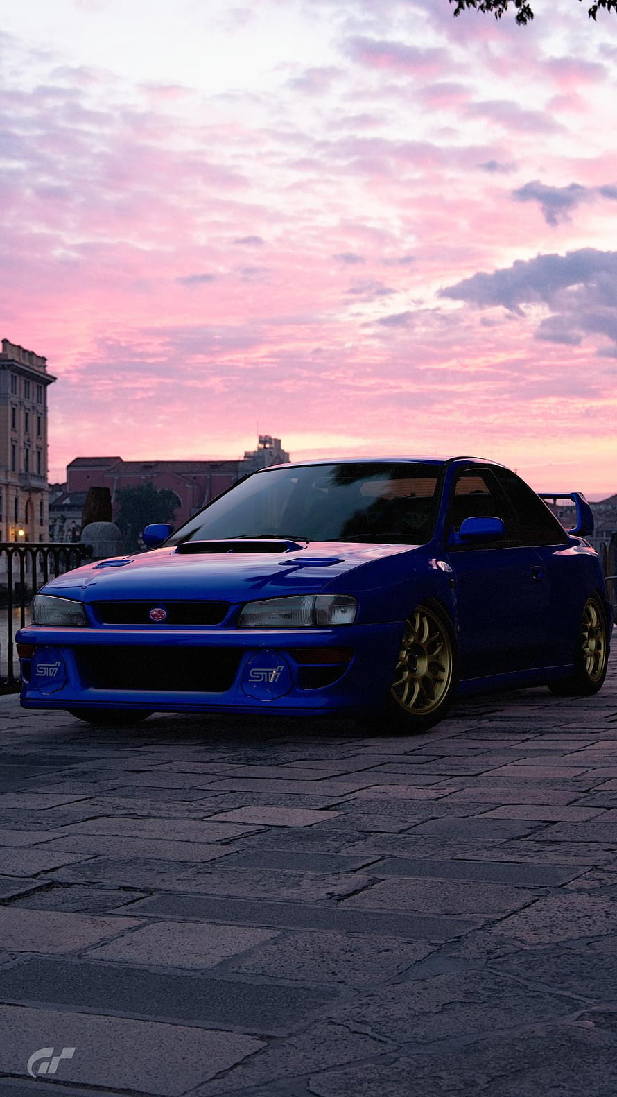 Blue Subaru Impreza STI parked on cobblestones under a pink sunset sky HD phone wallpaper
