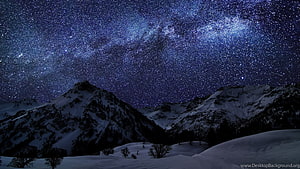 Milky Way Galaxy Arching Over Snow-Capped Mountain Peaks Under a Starry Winter Night Sky HD wallpaper