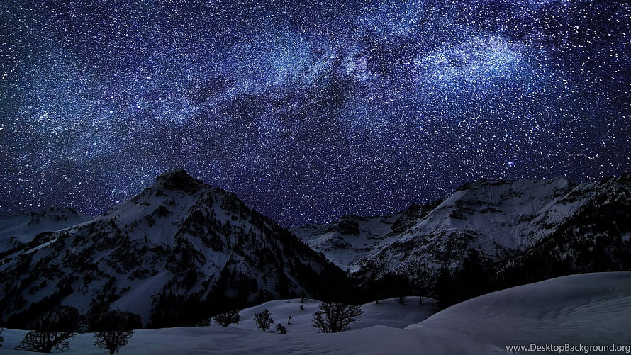 Milky Way Galaxy Arching Over Snow-Capped Mountain Peaks Under a Starry Winter Night Sky HD wallpaper