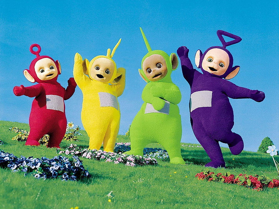 Teletubbies Characters Dancing on a Flower-Filled Meadow Under a Clear Blue Sky HD wallpaper