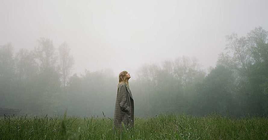 Taylor Swift in a misty green field from the Folklore album era HD wallpaper