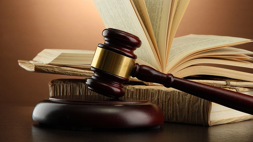 Wooden Gavel Resting on Open Law Books with Brass Band and Sound Block HD wallpaper