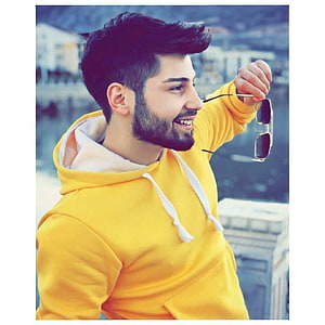 Smiling man in yellow hoodie holding sunglasses with urban background, Boys, boys attitude, boys dpz, boys pic, boys , handsome, smart and attitude boys HD phone wallpaper