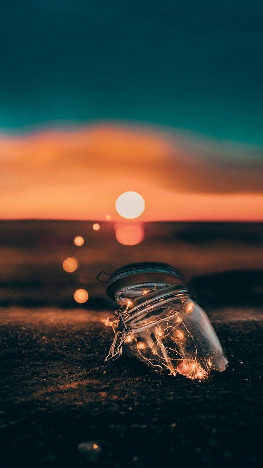 Glass Jar with Fairy Lights on a Beach at Sunset HD phone wallpaper