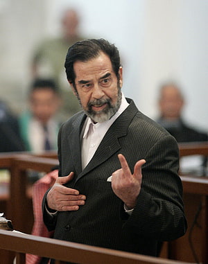 Saddam Hussein Gesturing During His Trial in a Formal Courtroom Setting HD phone wallpaper