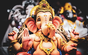 Ornate Golden Lord Ganesha Idol with Traditional Jewelry and Sacred Markings HD wallpaper