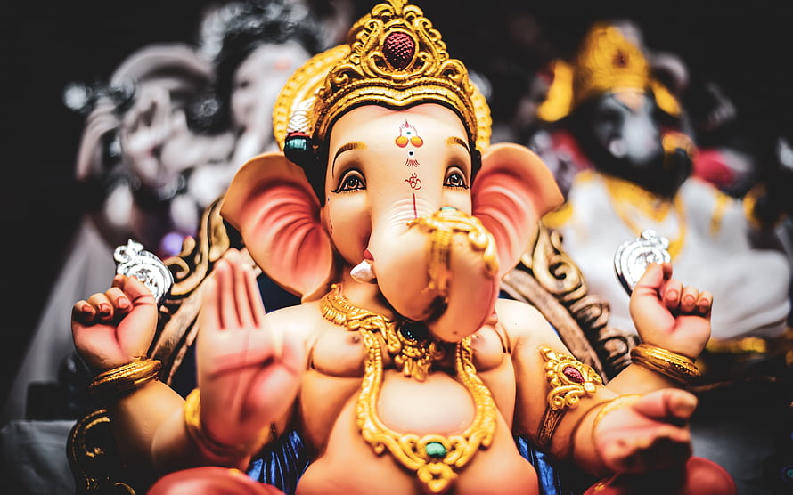 Ornate Golden Lord Ganesha Idol with Traditional Jewelry and Sacred Markings HD wallpaper