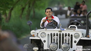 Sukha Kahlwan driving a white vintage jeep through a lush green forest road HD wallpaper