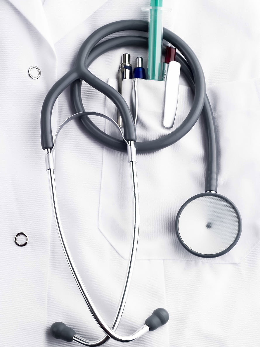 Stethoscope and medical instruments resting on a white doctor's lab coat HD phone wallpaper