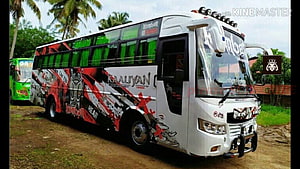 Komban Tourist Bus with Red and Black Graphic Wrap Parked in Tropical Setting HD wallpaper