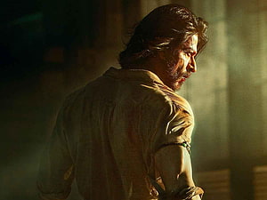Shah Rukh Khan in dramatic profile from Pathaan with intense cinematic lighting HD wallpaper