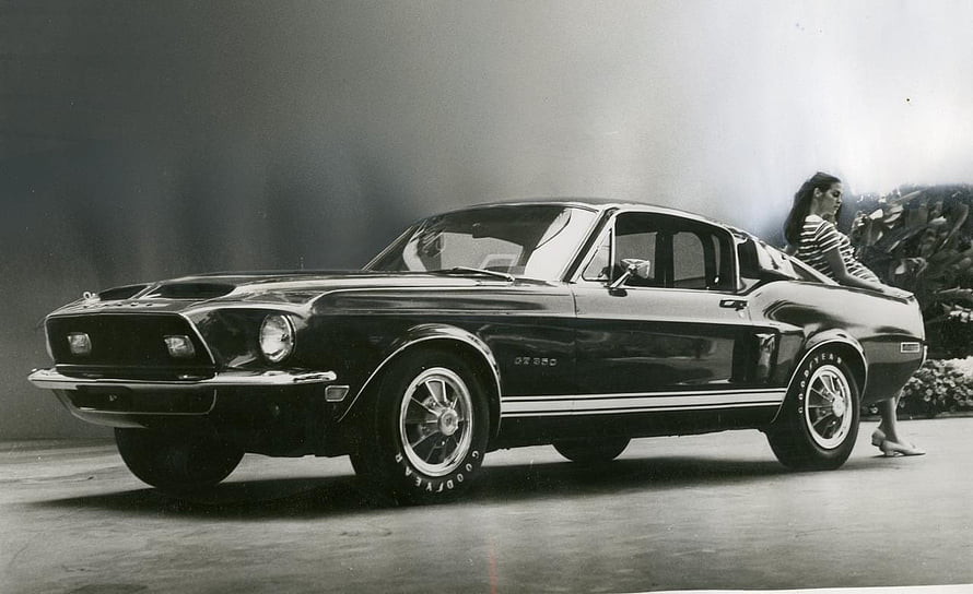 Vintage Ford Mustang Fastback with Model in Black and White Studio Photography HD wallpaper