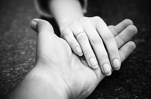 Black and white close-up of two hands gently clasped with a simple ring HD wallpaper