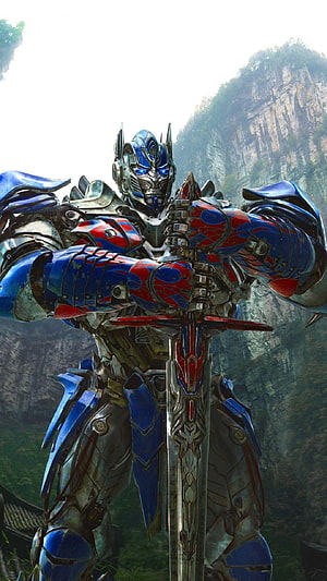 Optimus Prime from Transformers Age of Extinction gripping a sword in a misty mountain landscape HD phone wallpaper