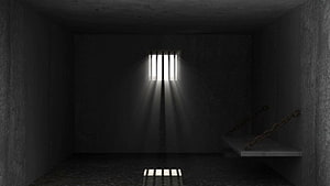 Dark Prison Cell Interior with Barred Window and Hanging Chains HD wallpaper