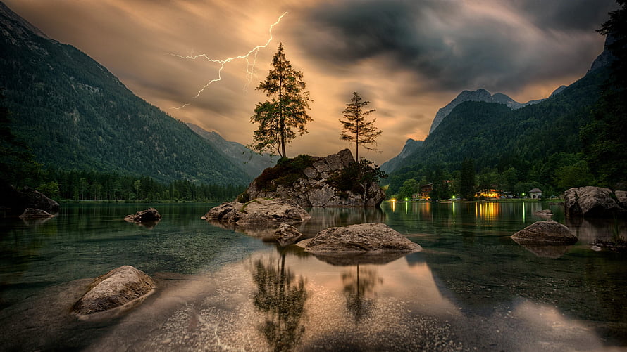 Dramatic Lightning Strike Over Mountain Lake with Solitary Trees and Rocky Outcrop HD wallpaper