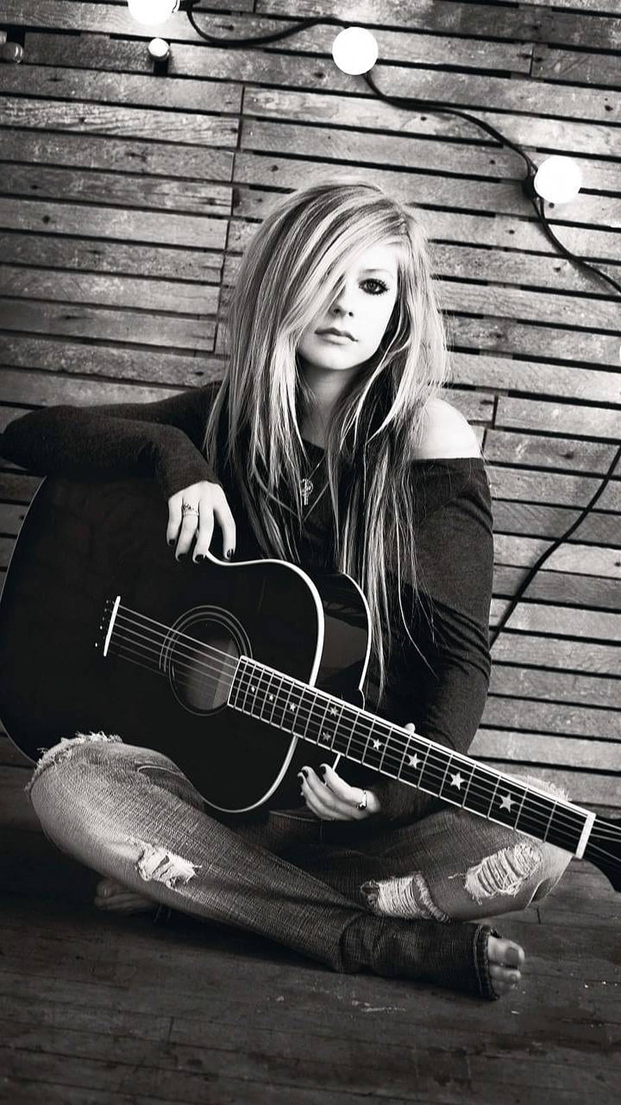 Avril Lavigne Sitting Cross-Legged With Acoustic Guitar Against Rustic Wooden Wall HD phone wallpaper