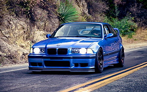 Blue BMW E36 M3 Coupe Driving on a Mountain Road with Custom Widebody Kit HD wallpaper
