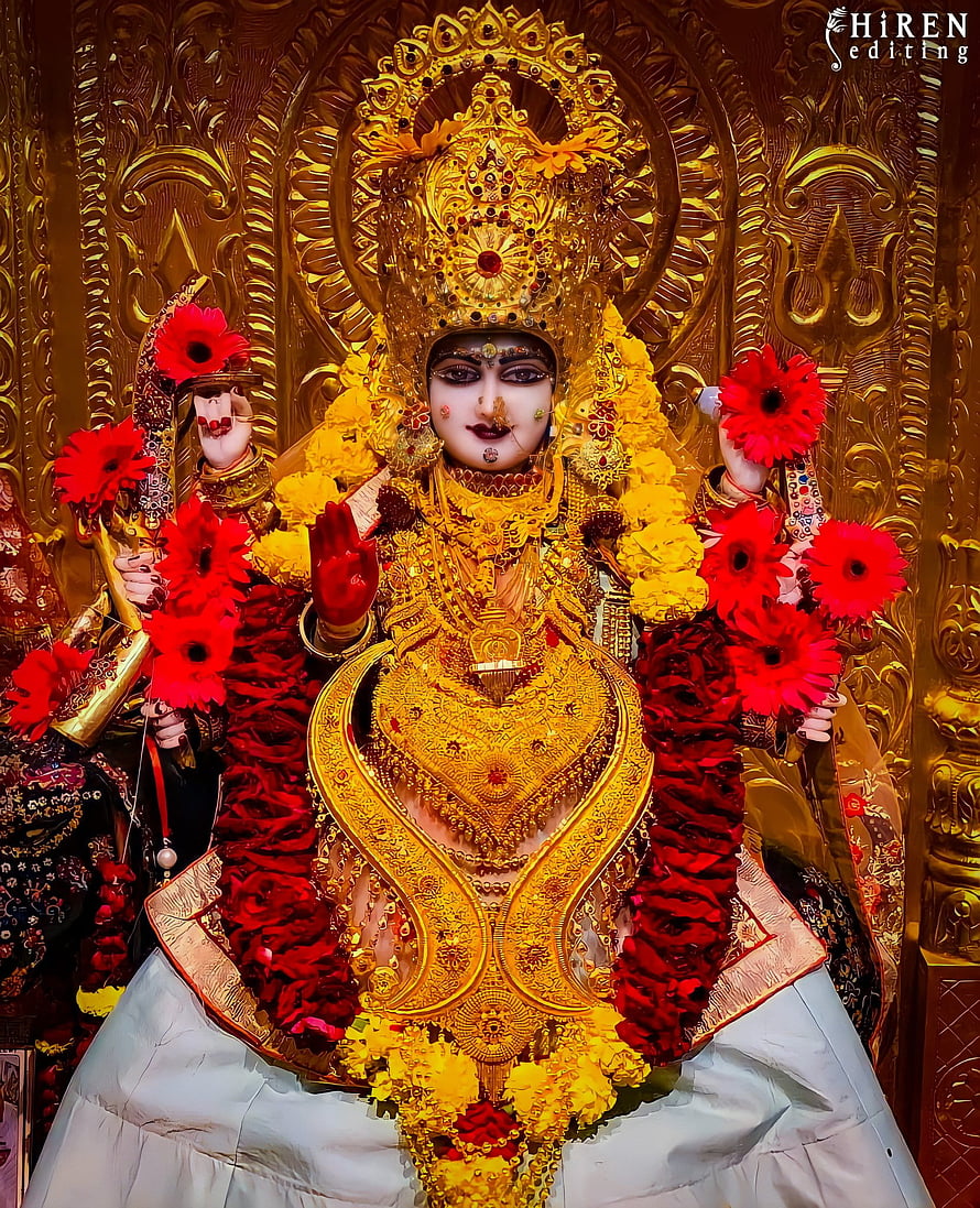 Meldi Maa Malataj Divine Idol Adorned in Gold Jewelry and Vibrant Flower Garlands HD phone wallpaper