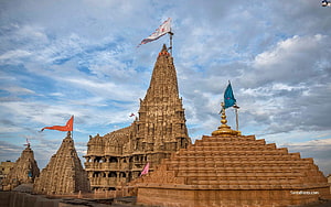 Dwarkadhish Temple in Dwarka, Gujarat, India with colorful flags against a cloudy sky HD wallpaper