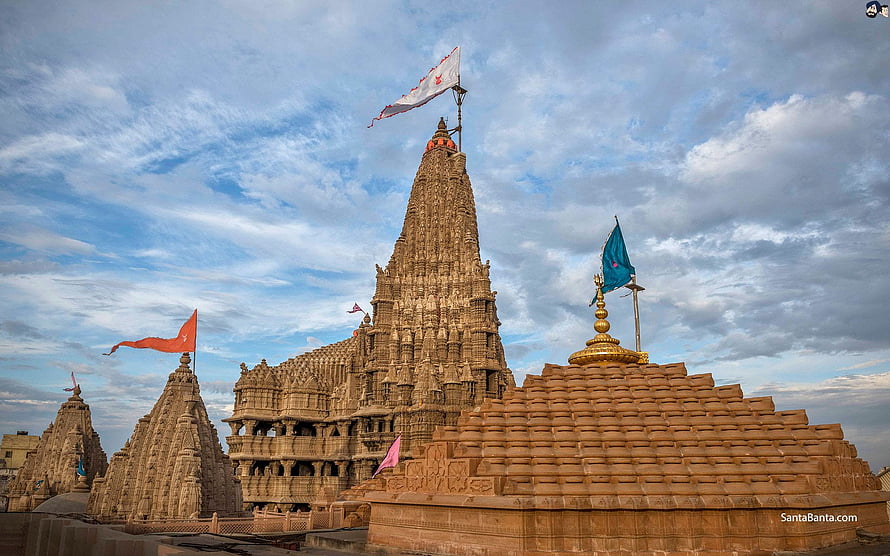 Dwarkadhish Temple in Dwarka, Gujarat, India with colorful flags against a cloudy sky HD wallpaper