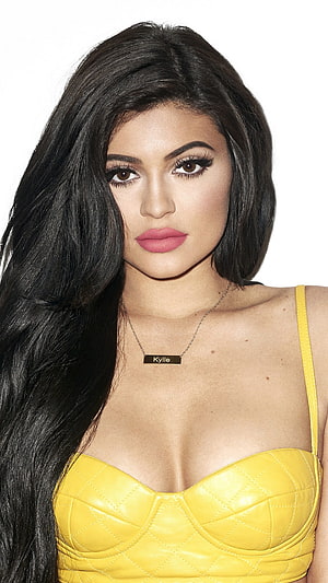 Kylie Jenner in a yellow quilted top with long dark hair and a nameplate necklace HD phone wallpaper