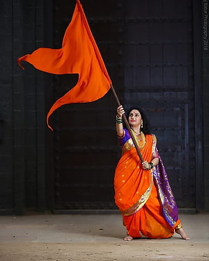 Woman in Orange Saree Holding Bhagwa Flag in Traditional Indian Attire HD phone wallpaper