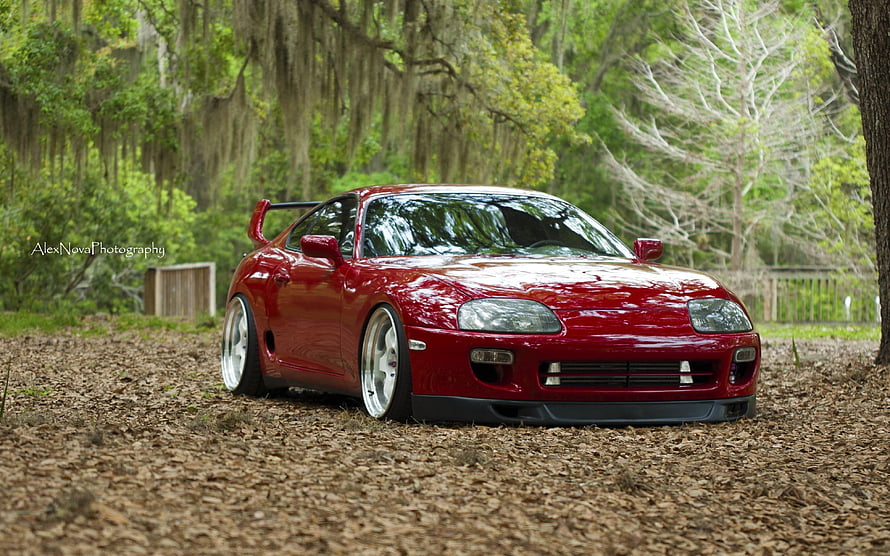 Red Toyota Supra MK4 Stance Build Parked in a Lush Forest Clearing HD wallpaper