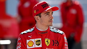 Charles Leclerc in Ferrari Racing Suit and Cap at Formula 1 Pit Lane HD wallpaper