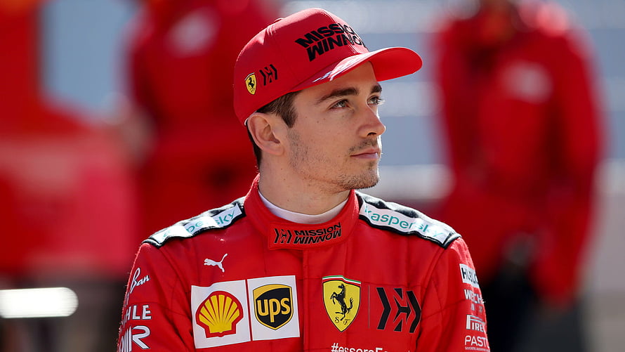 Charles Leclerc in Ferrari Racing Suit and Cap at Formula 1 Pit Lane HD wallpaper