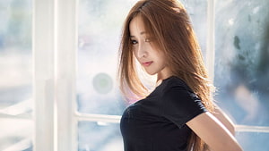 Young Asian Woman in Black Top Standing by a Bright Window HD wallpaper