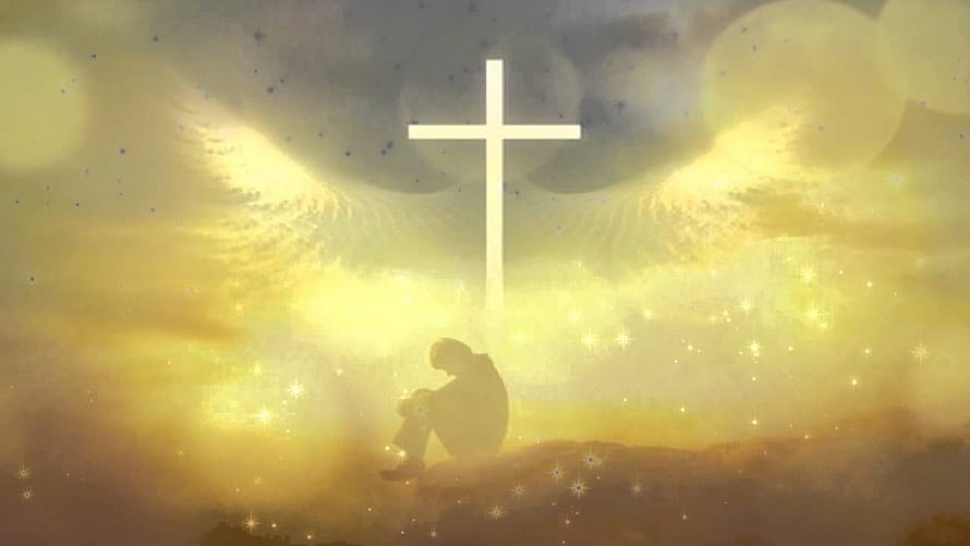 Silhouette of a person in prayer beneath a glowing cross with angel wings and golden light HD wallpaper