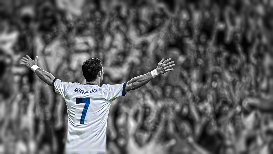 Cristiano Ronaldo celebrating with arms raised in white jersey before a stadium crowd HD wallpaper