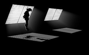 Silhouette of a Hanging Figure in a Dark Room with Blinds and Light Beams HD wallpaper